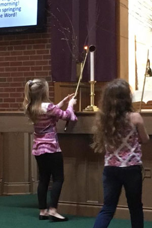 Two girls lighting the candles.